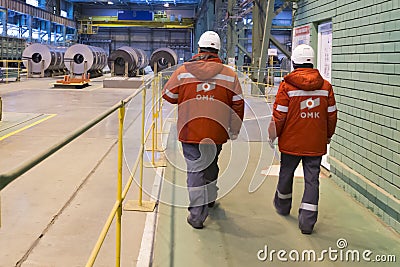 Vyksa, Russia: 12.23.2018. Workers walk in a hot rolled strip steel product warehouse. Finished metal casting and rolling Editorial Stock Photo