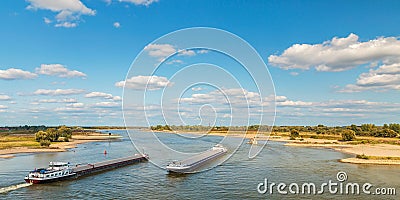 The Waal river near Nijmegen with cargo ships passing by Stock Photo