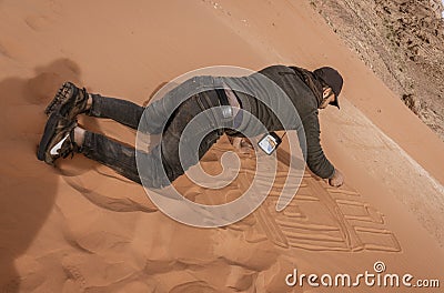 Wadi Rum, Jordan - 2019-04-23 - Man draws intricate patterns in the sand dune Editorial Stock Photo