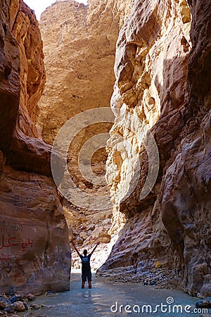 Young adventurous man in Wadi Zarqa Ma`in canyon located in the mountainous landscape to the east of the Dead Sea, near to Wadi M Editorial Stock Photo