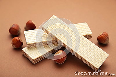 Wafers, cookies and sweets concept with hazelnut, chocolate and vanilla filled wafer stack with raw hazelnuts on a brown Stock Photo