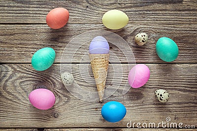 Waffle cone with Easter eggs on old wooden background. Space for Stock Photo