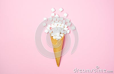 Waffle cone with white mini marshmallows on a pink background Stock Photo