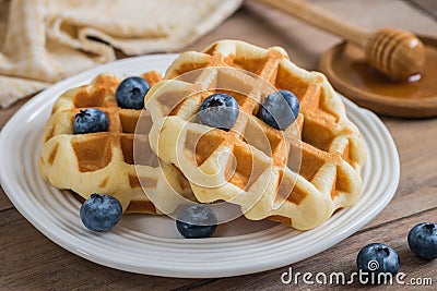 Waffle with fresh blueberry on plate and honey dipper Stock Photo