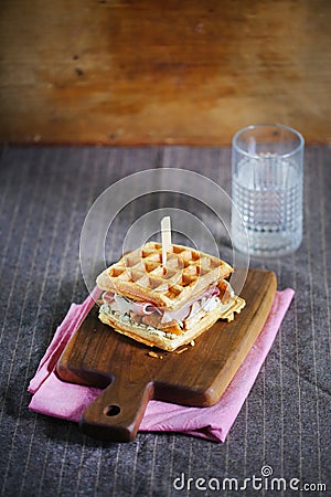 Waffle sandwich with cheese, prosciutto and chanterelles, gourmet Stock Photo