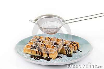 Waffles with chocolate on a blueish plate. Some powdered sugar i Stock Photo