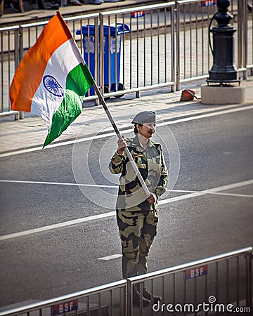 Wagah border, Punjab, India - April 14th, 2019 : A lady officer of Indian Border Security Force, waving Indian National Flag Editorial Stock Photo