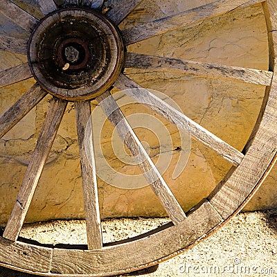 Detail of a wagon wheel against a wall Stock Photo