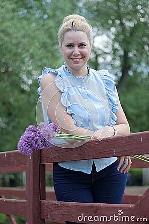 A waist portrait of a woman with a bouquet of wildflowers. Looks into the camera Stock Photo