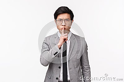 Waist-up of angry and disappointed young asian office manager, employer shushing at person being rude, talking too loud Stock Photo