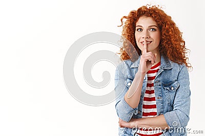 Waist-up happy redhead curly cheerful feminine woman hiding interesting surprise shushing have secret show shhh sign Stock Photo