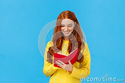 Waist-up portrait redhead female student write down thoughts in red lovely notebook, prepare grocery list, make schedule Stock Photo