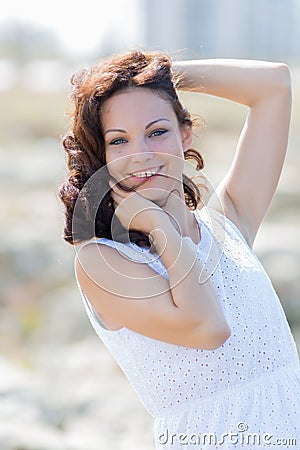 Waist up portrait of young woman in white sleeveless dress Stock Photo