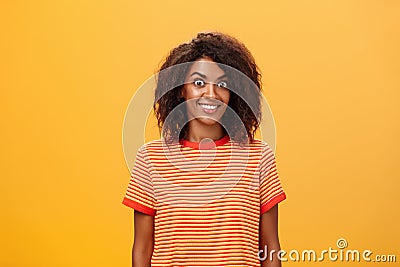 Waist-up shot of amazed and excited charming african american woman with curly hairstyle popping eyes from thrill and Stock Photo