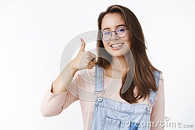 Waist-up shot of charming happy and delighted female freelancer assuring work done in time showing thumbs up and smiling Stock Photo