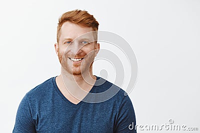 Waist-up shot of charming redhead mature european man with bristle and beautiful natural blue eyes standing over gray Stock Photo