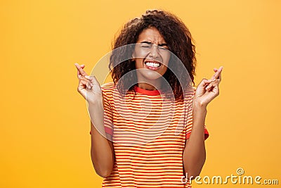 Waist-up shot of concerned worried woman eager take important job crossing fingers for good luck clenching teeth and Stock Photo