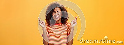 Waist-up shot of concerned worried woman eager take important job crossing fingers for good luck clenching teeth and Stock Photo