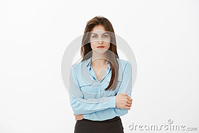 Waist-up shot of confident good-looking successful entrepreneur in blue blouse, holding hands together on chest and Stock Photo