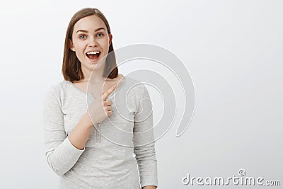 Waist-up shot of enthusiastic pleasant young european woman with short brown hair smiling broadly telling interesting Stock Photo