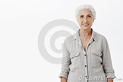 Waist-up shot of kind and cute energized grandmother with gray hair in casual shirt smiling broadly with happy Stock Photo