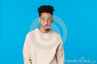 Waist-up shot moody and home-sick handsome african-american guy fooling around, feeling bored and unamused showing Stock Photo