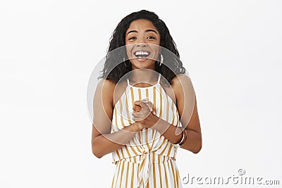 Waist-up shot of pleased and delighted happy young african american successful businesswoman in elegant striped yellow Stock Photo