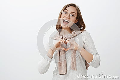 Waist-up shot of sociable happy and friendly caucasian brunette in trendy glasses, blouse and pullover tied over neck Stock Photo