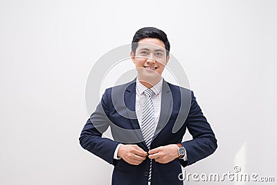 Waistup portrait of young smiling handsome businessman putting on suit jacket looking aside isolated on white Stock Photo