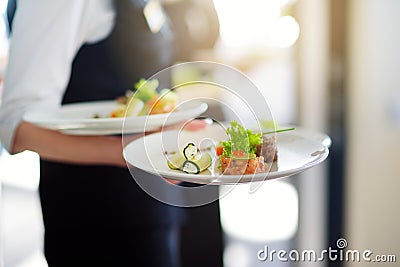 Waiter carrying plates with meat dish on some festive event Stock Photo