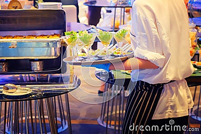 Waiter carrying plates with salad seafood in glass on some festive event, party or wedding reception Stock Photo