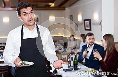 Waiter dissatisfied with small tip from restaurant visitors Stock Photo