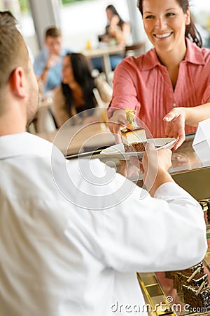 Waiter giving woman cake plate at cafe Stock Photo