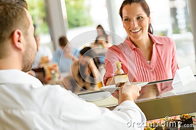 Waiter giving woman cake plate at cafe Stock Photo