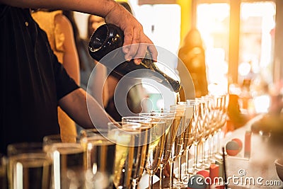 Waiter pouring champagne into glasses on party event in the bar. Stock Photo