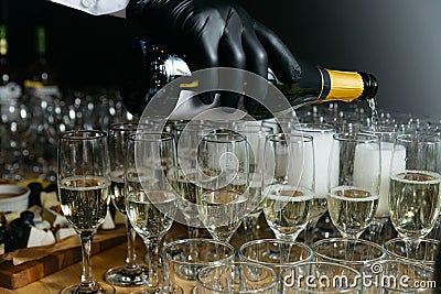 waiter pours champagne into glasses, close-up of the hands Stock Photo