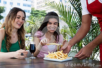 Waiter serving french fries to guests Stock Photo