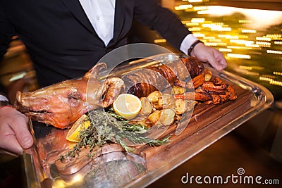 Waiter serving pork in luxury party in restaurant. Stock Photo