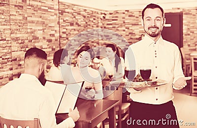 Waiter serving restaurant guests Stock Photo