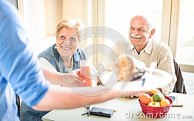 Waiter serving retired senior couple eating at vegan restaurant Stock Photo