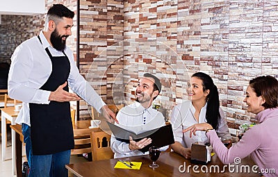 Waiter serving rural restaurant guests at table Stock Photo