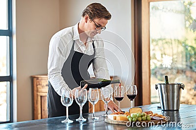 Waiter, wine tasting, and bartender with glass at fine dining vineyard restaurant in countryside. Professional sommelier Stock Photo