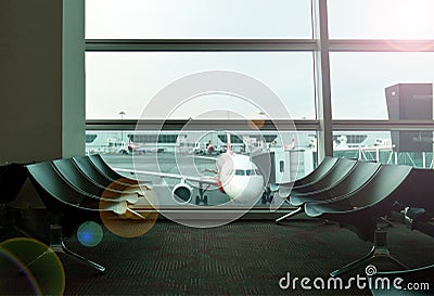 Waiting seats at airport gate with airplanes in distance Stock Photo