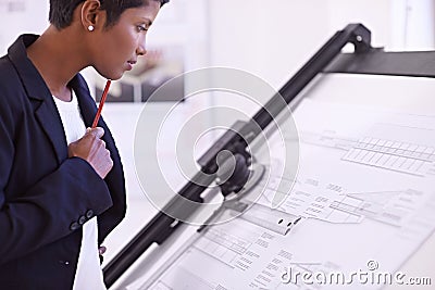 Waiting for some inspiration. a female architect working at a drawing board. Stock Photo