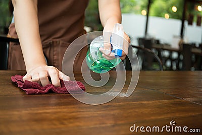 Waitress cleaning the table with spray disinfectant Stock Photo