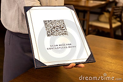 Waitress display contactless menu with QR code as part of new normal. Dummy QR Code Used Stock Photo