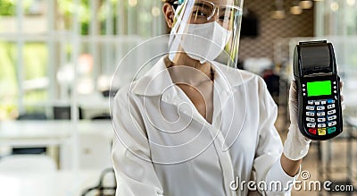 Waitress with face mask hold credit card reader Stock Photo