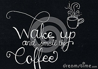 `Wake up and smell the coffee` hand lettering saying in white, chalk writing on a black paper Stock Photo