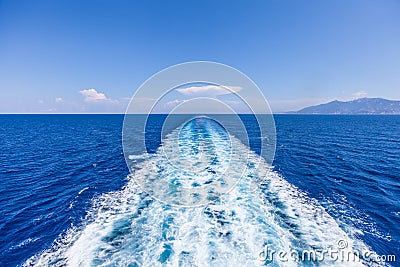 Wake of water from a boat, open sea with horizon and blue sky Stock Photo