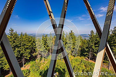 Beautiful green and blue landscape full of high trees and mountains seen from behind bars of Editorial Stock Photo